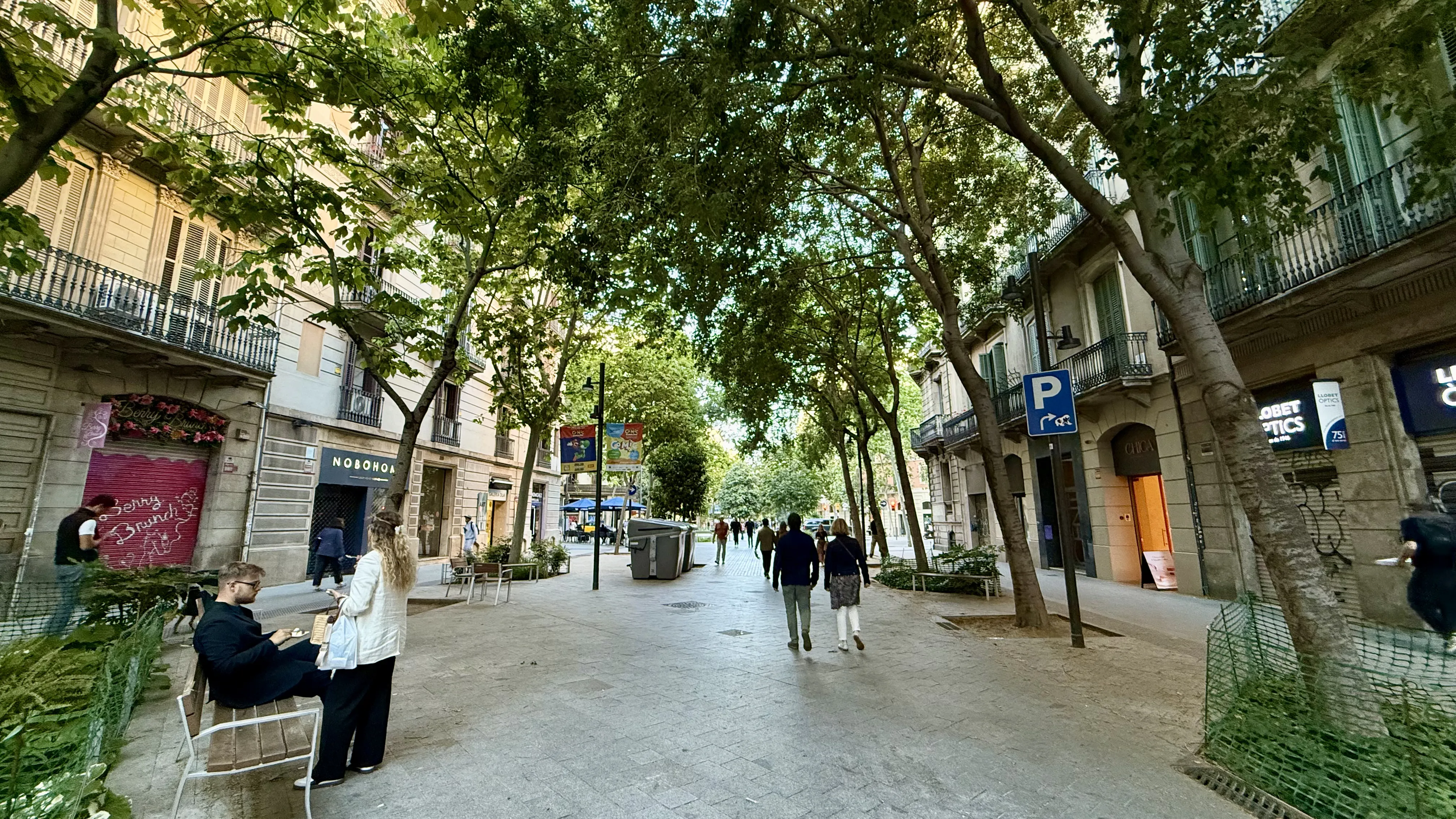 A Superilla pedestrian street in Barcelona, tree lined, car free, alive with people