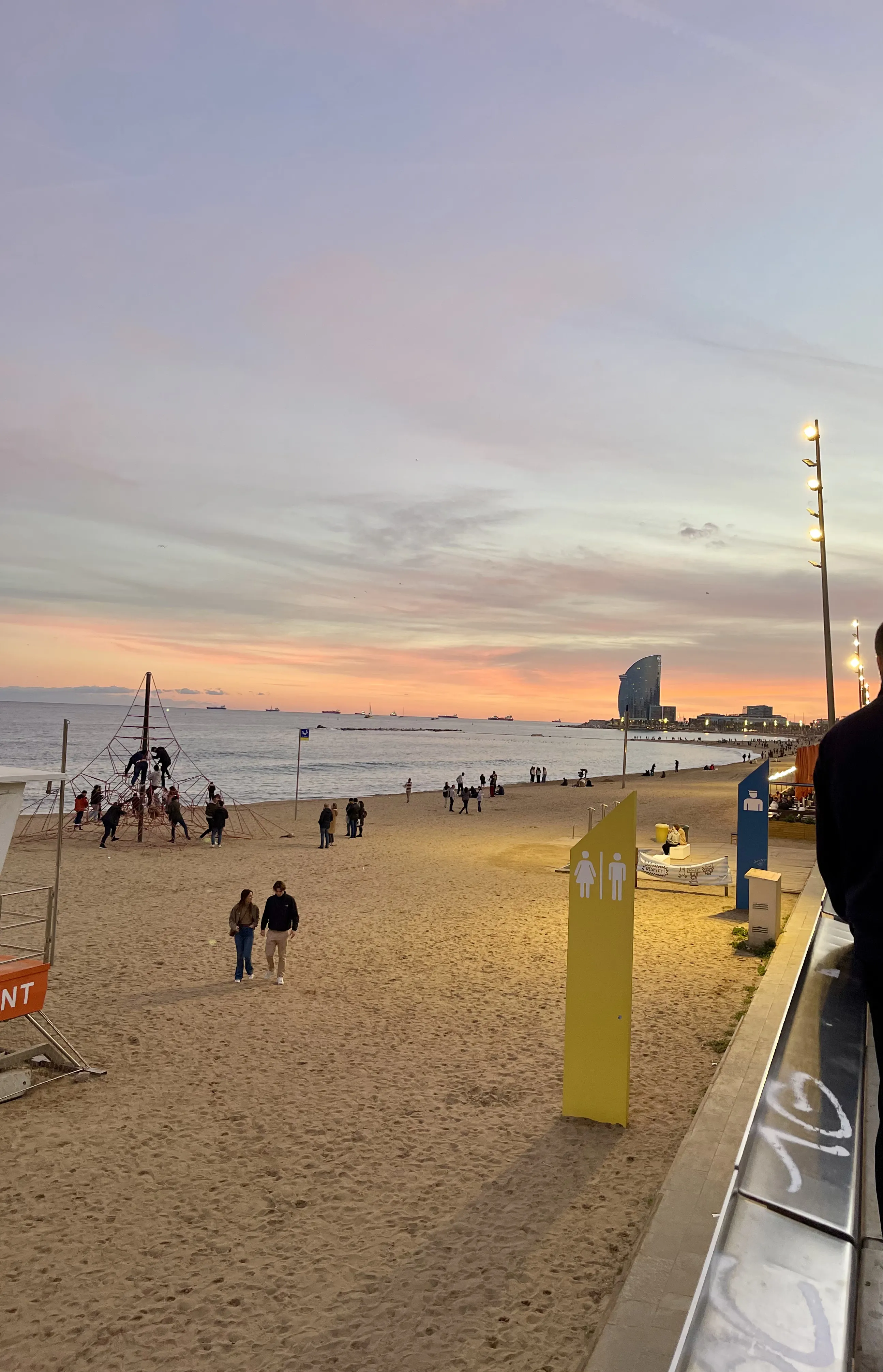 Platja de Sant Miquel in Barceloneta with pine trees and the W Hotel Barcelona in the background, early morning