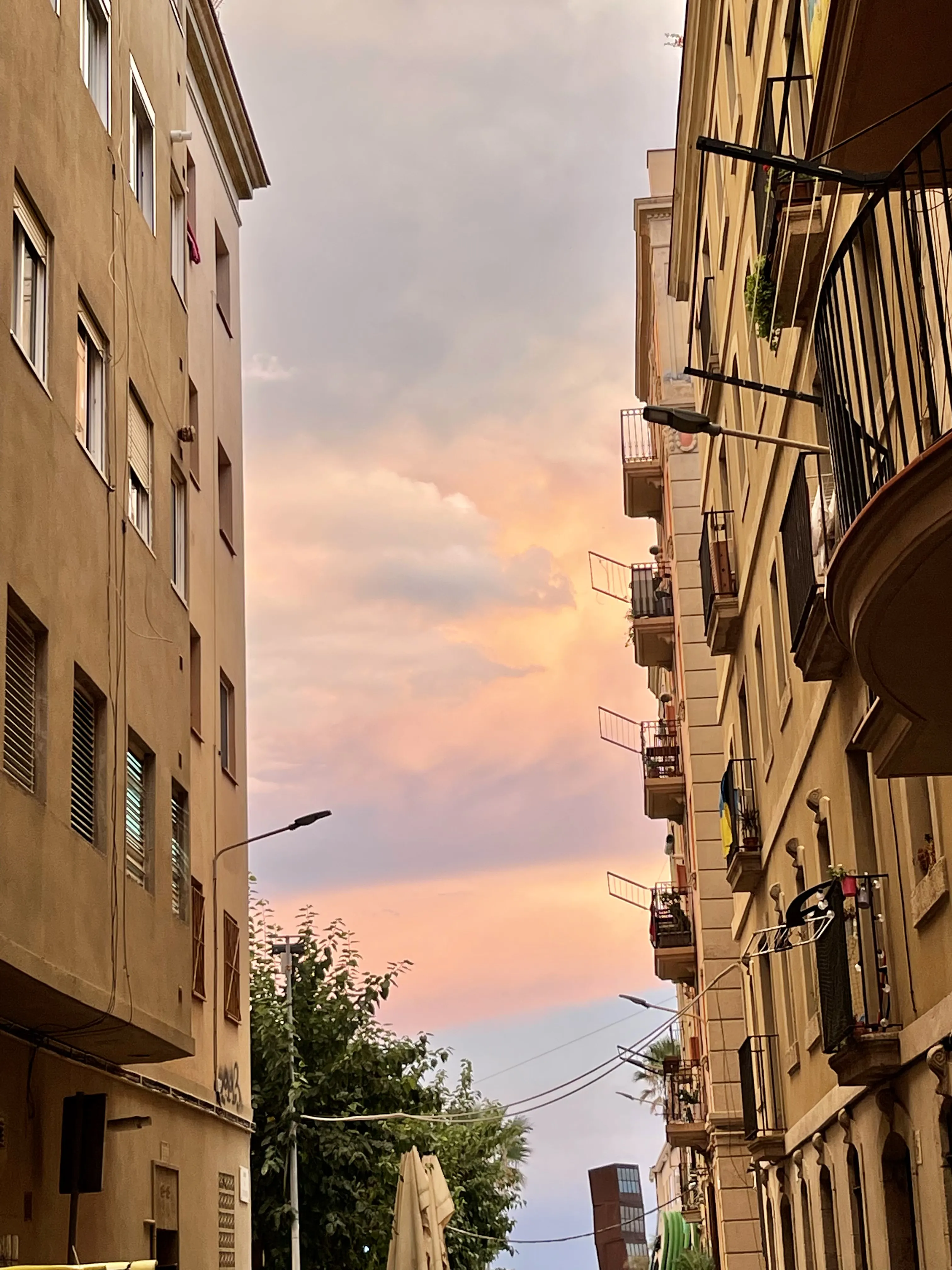 Barceloneta street at sunset with an orange sky over the balconies, Barcelona