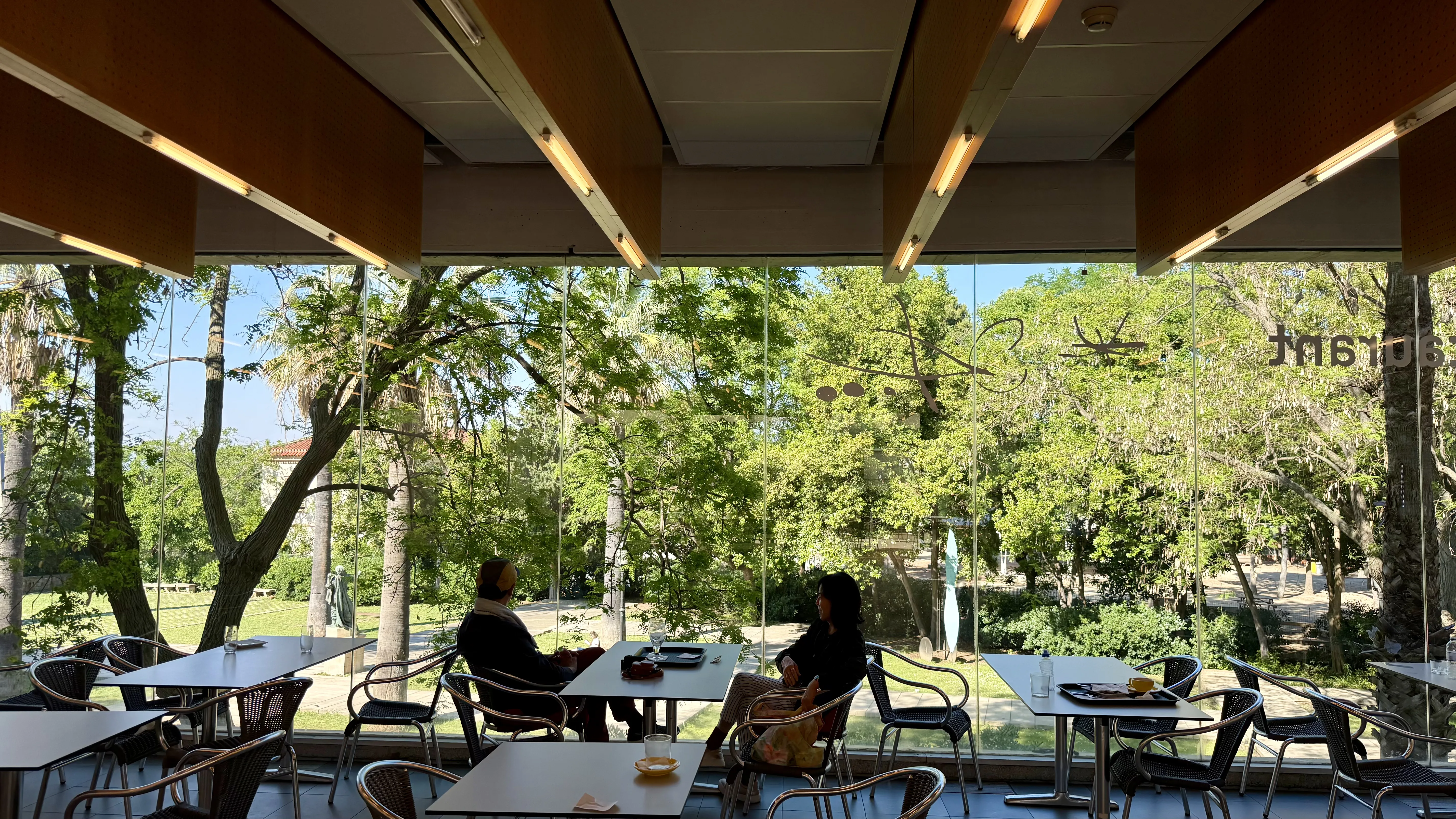 Glass-walled cafeteria at the Fundació Joan Miró surrounded by greenery